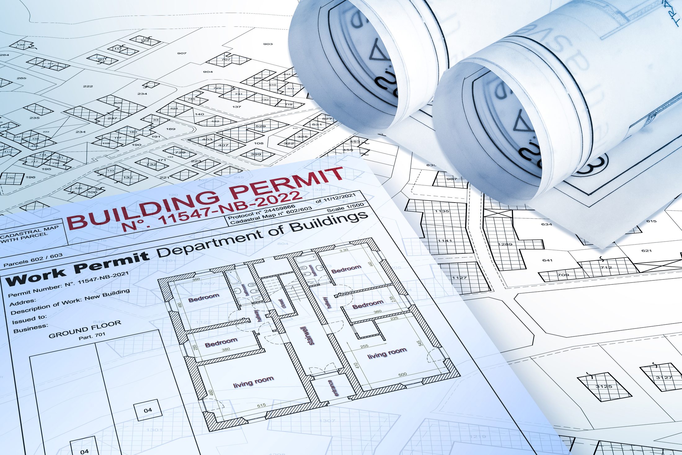 A building permit and work permit document laid over cadastral parcel maps and rolled site plans